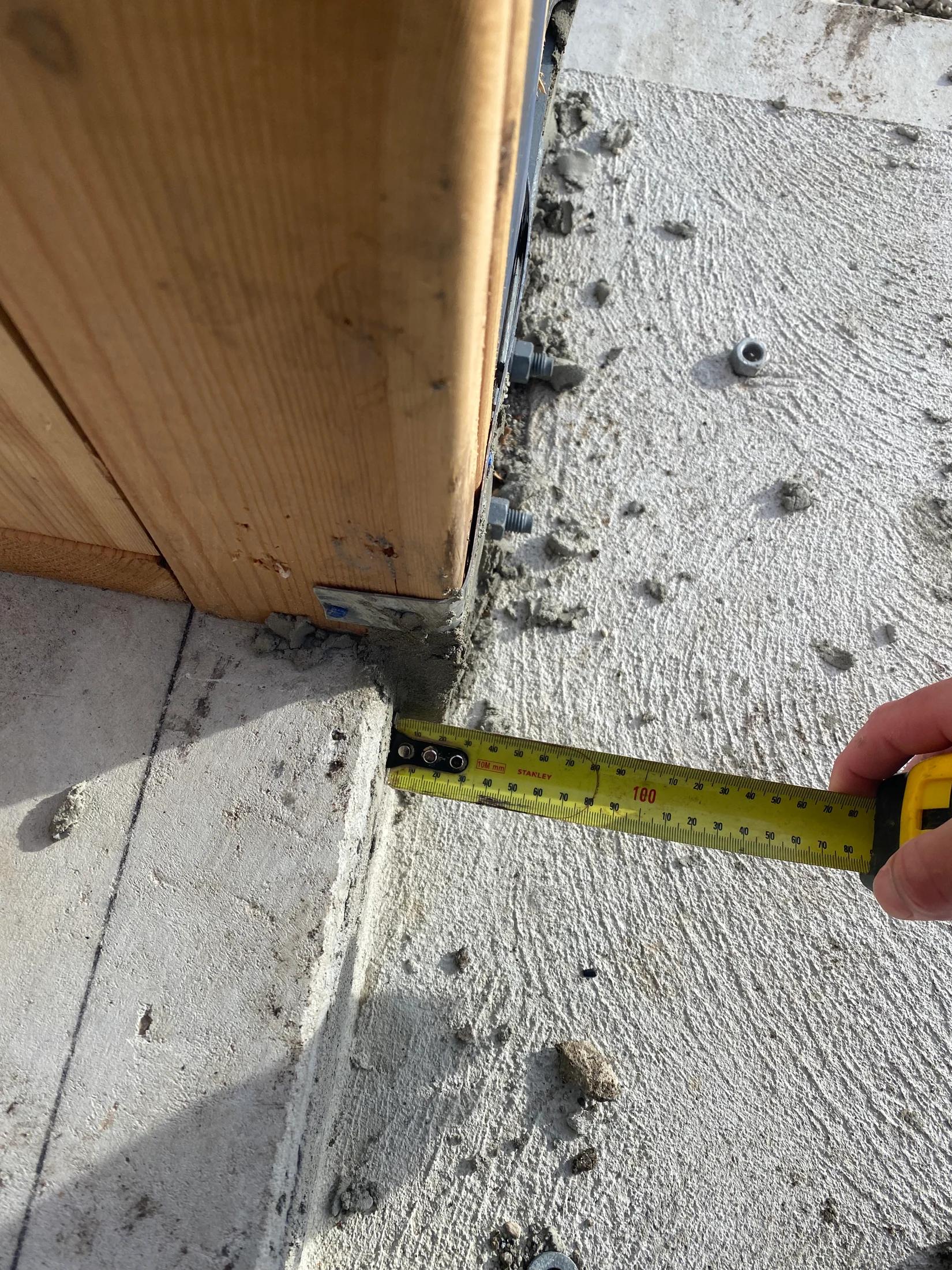 Corner timber stud on alfresco, being checked by inspector