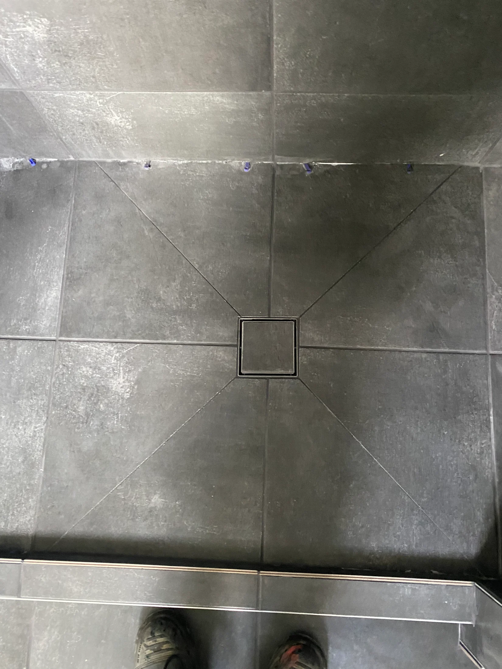 Tiled shower base with defective tile fall, causing water pooling