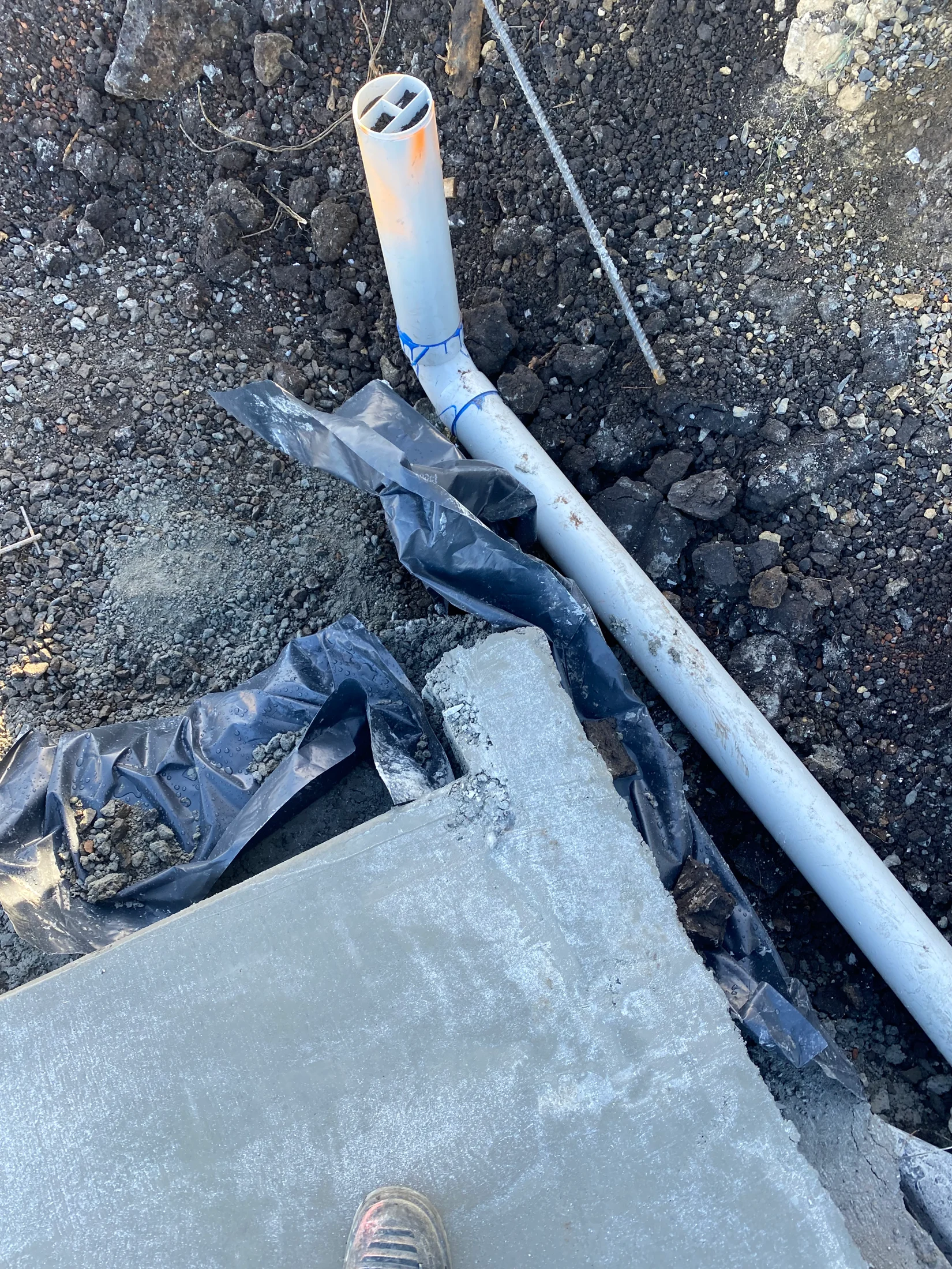 Picture of an exposed stormwater drain, ready for inspection and backfilling on construction site at slab stage