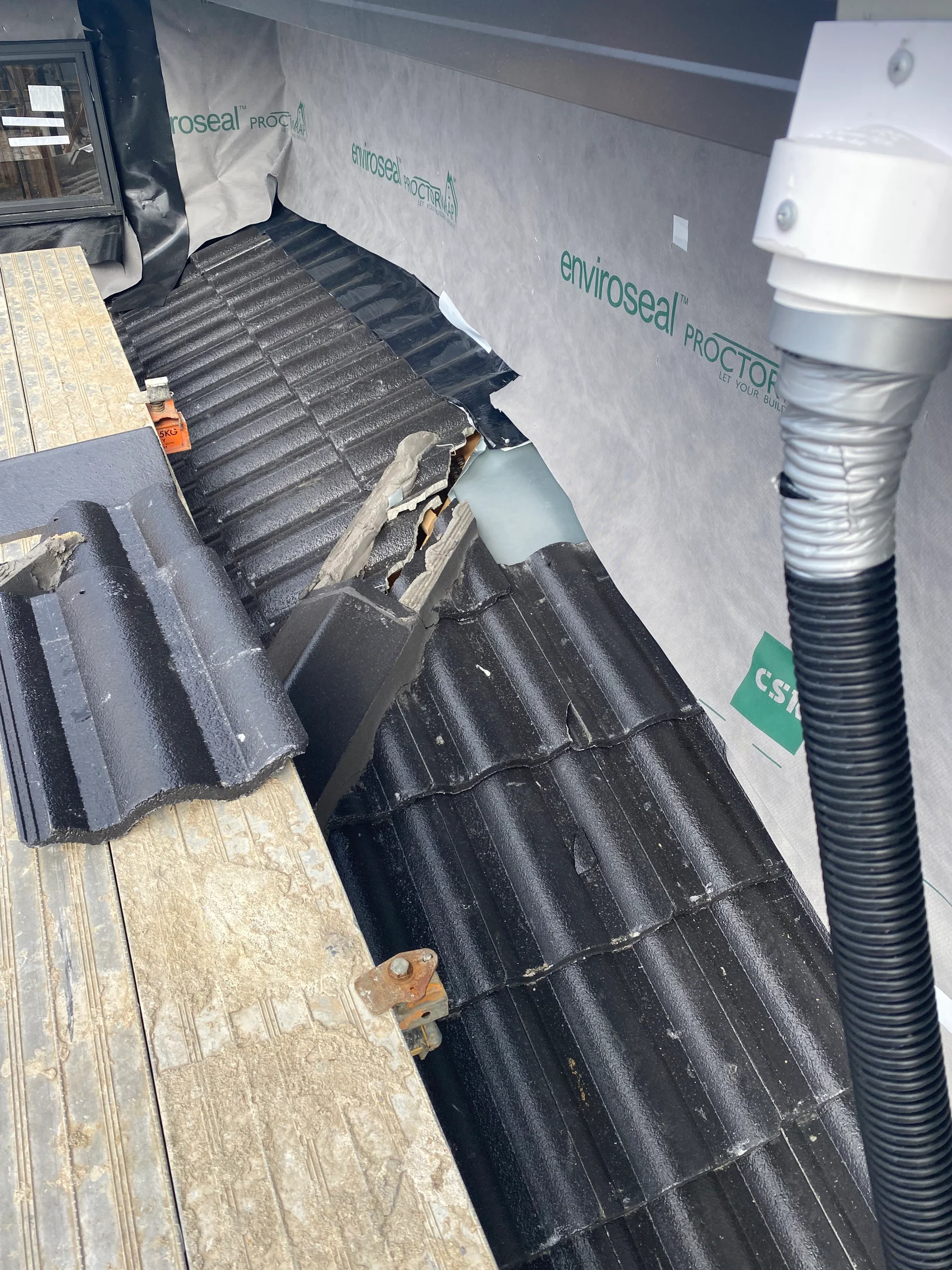 Lower roof construction set up with lead flashings and temporary downpipes in photo