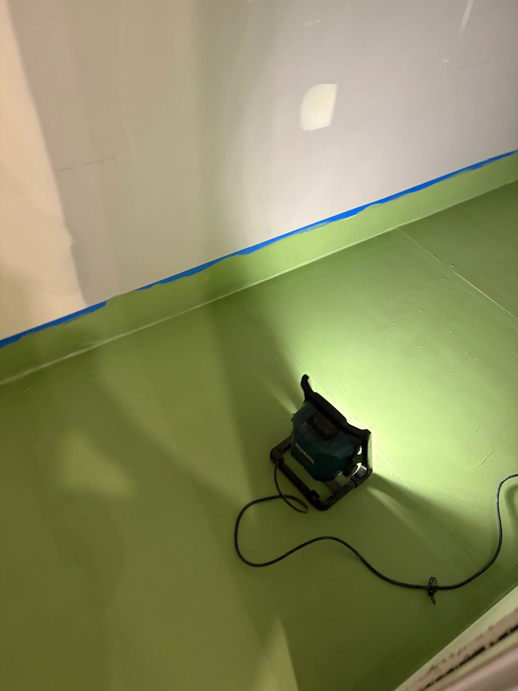 A light shining on a freshly waterproofed floor in a construction site