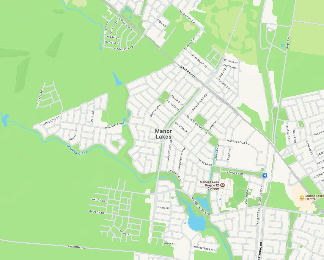 Map of Manor Lakes suburb with street names, green park areas, and water bodies. Key locations: Manor Lakes Central and Prep-12 College.